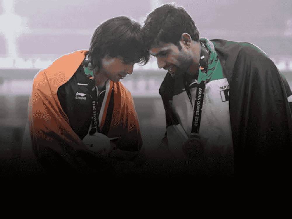 Neeraj Chopra on left and Arshad Nadeem on right shaking hands at Asian Games 2018, highlighting their past sportsmanship amid recent invite decline for Bengaluru event.