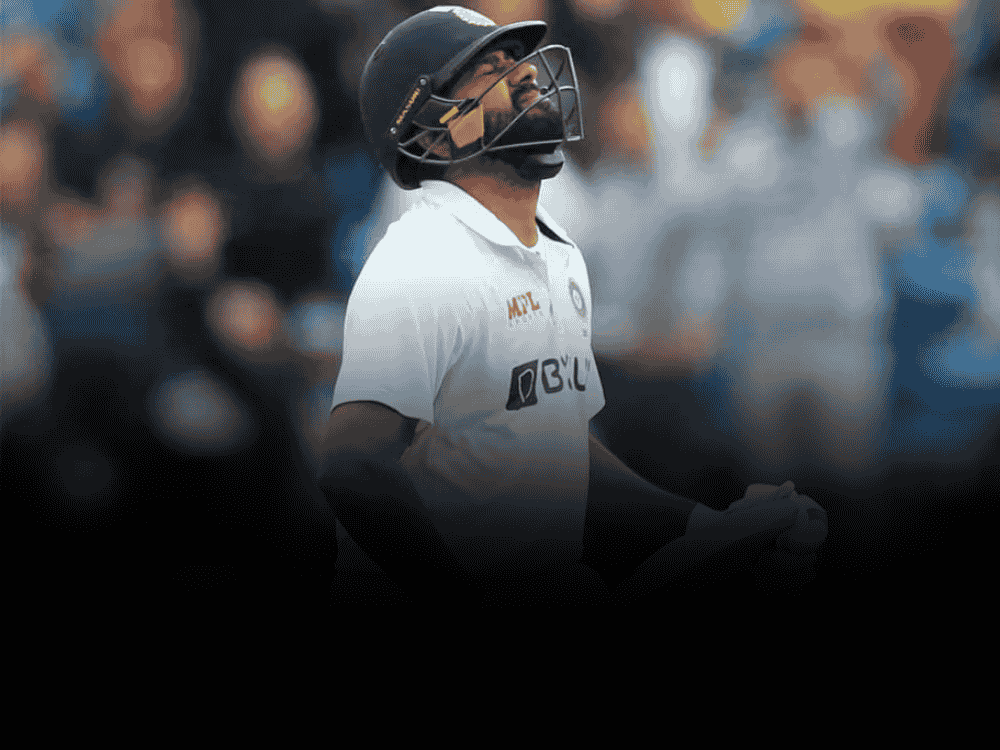 Rohit Sharma, who has recently retired from test cricket, in white test jersey, walking back with a sad face after dismissal in a test match.